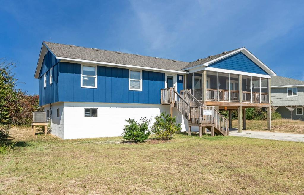a blue and white house with a deck at Laughing Place - Southern Shores, 175 Ft to Beach, Pool Table, Pets OK, Flex Stays in Southern Shores