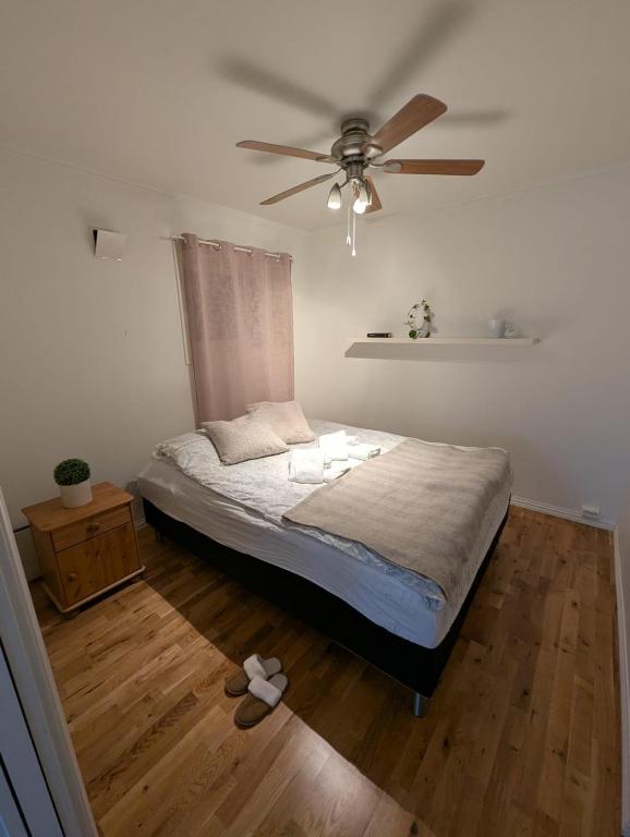 a bedroom with a bed with a ceiling fan at Cozy apartment in Tromsø