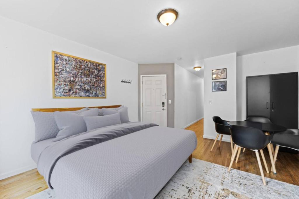 ホーボーケンにあるHoboken Studio 15 Min from Manhattanのベッドと机のある白い寝室