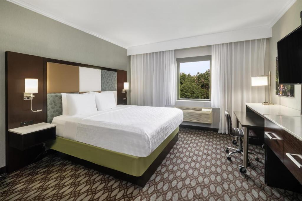 a hotel room with a bed and a desk and a window at Best Western Premier NYC Gateway Hotel in North Bergen