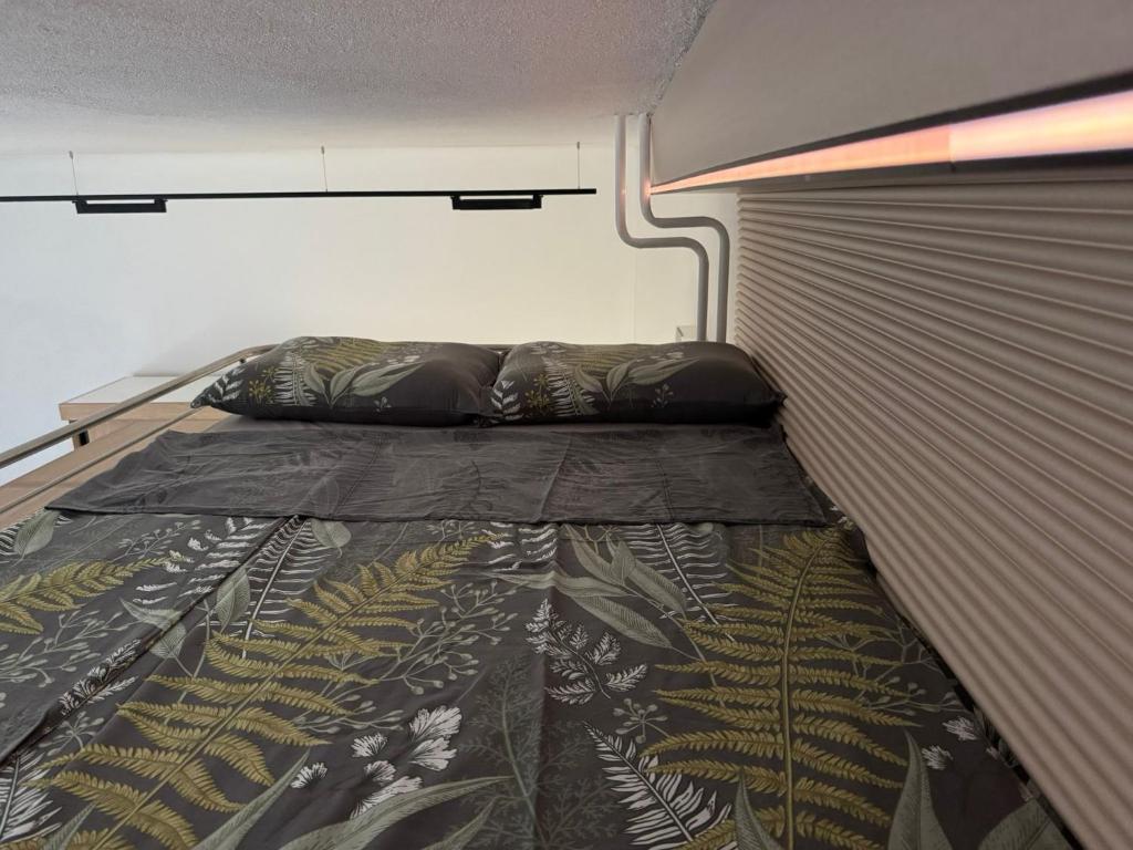 um quarto com uma cama com um padrão de folha em Stone Bridge Studio em Skopje