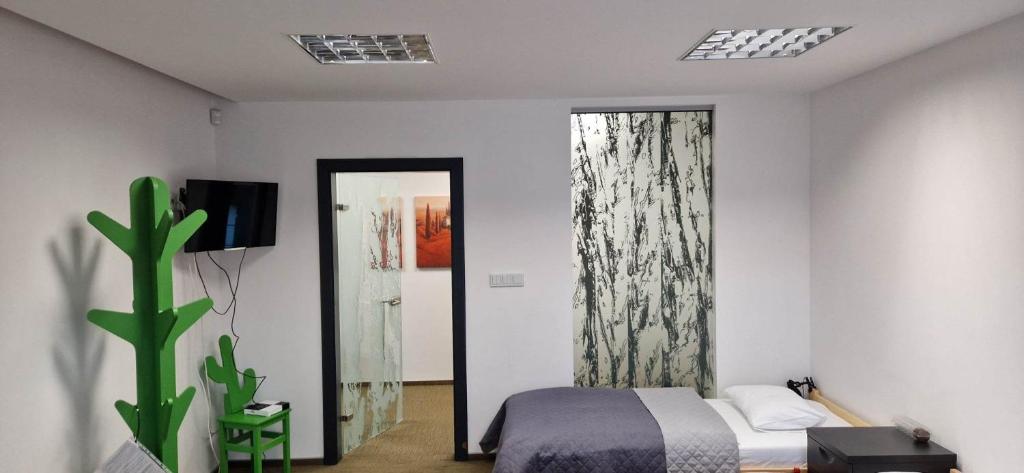 une chambre avec un lit et un miroir dans l'établissement Żołnierska Hostel, à Leszno