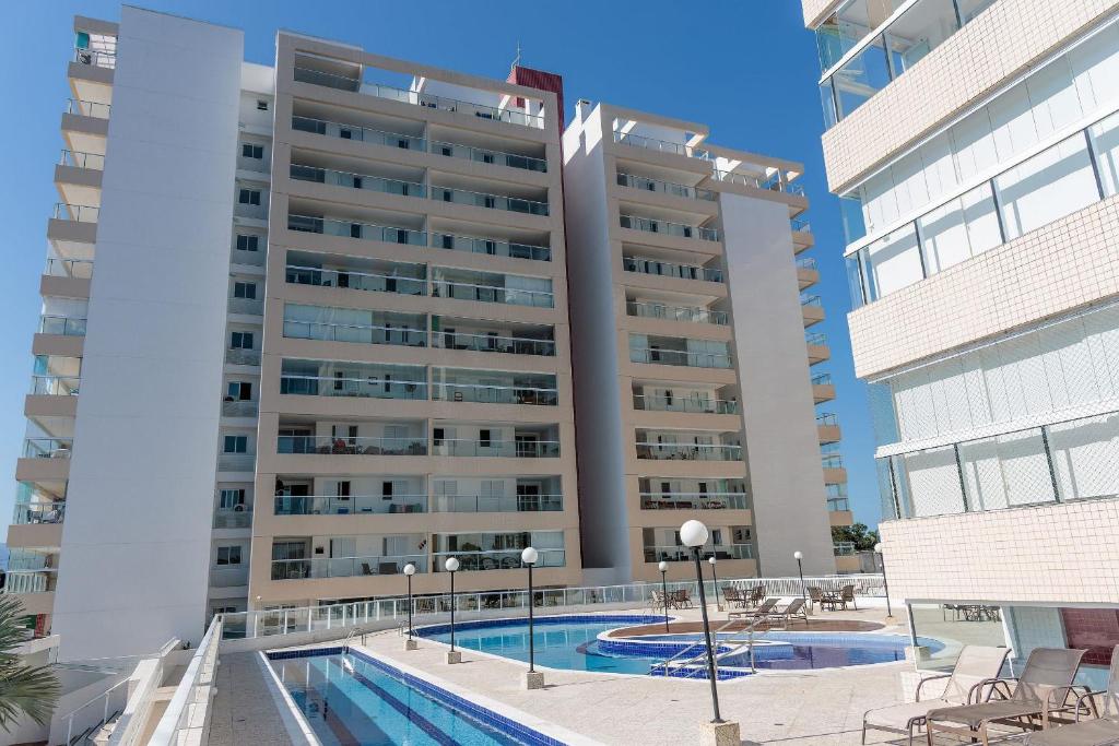 a large building with a swimming pool in front of it at 250m do Mar | Piscina e Roupas de Cama in Bertioga