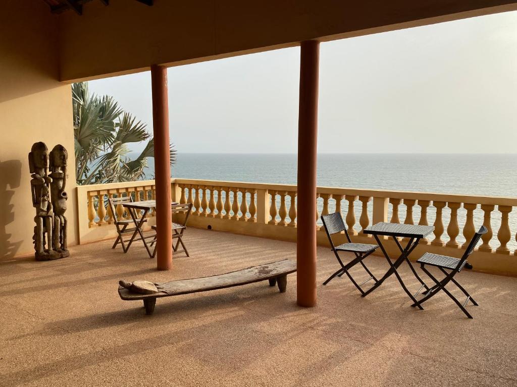 a porch with chairs and a bench on the beach at Villa Atlantique Toubab Dialo in Toubab Dialaw