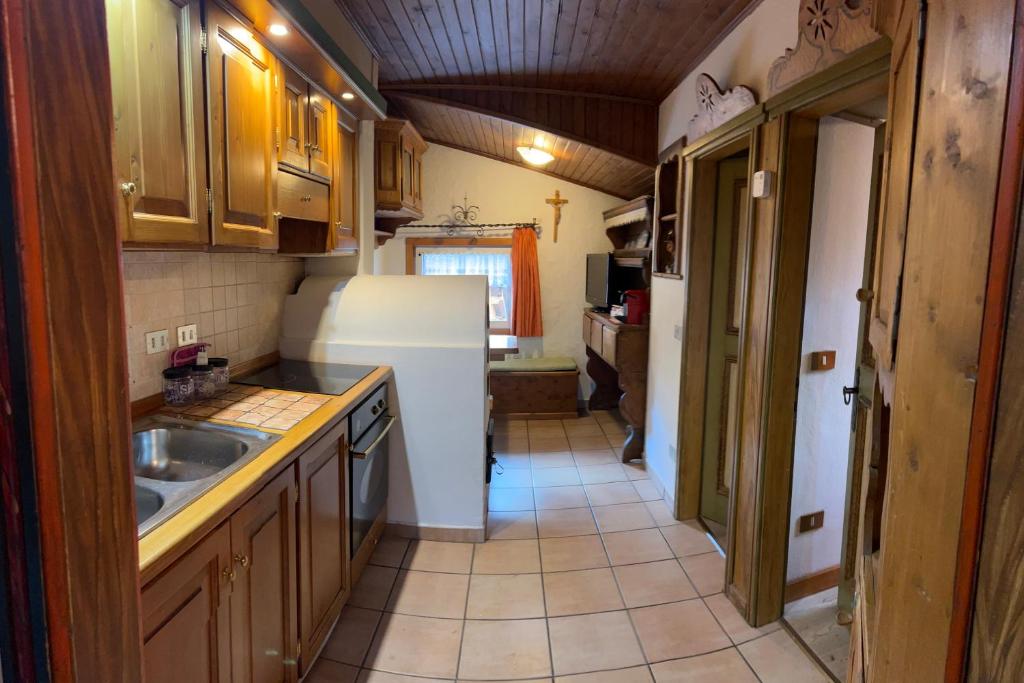a kitchen with a sink and a refrigerator at mansarda rustica in Padola