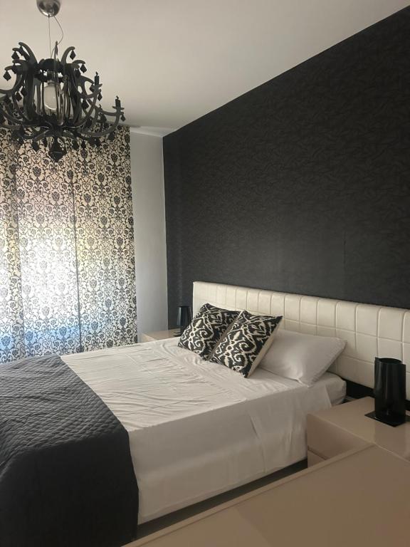 - une chambre avec un lit blanc et un mur noir dans l'établissement Casa di Eva, à Reggio de Calabre