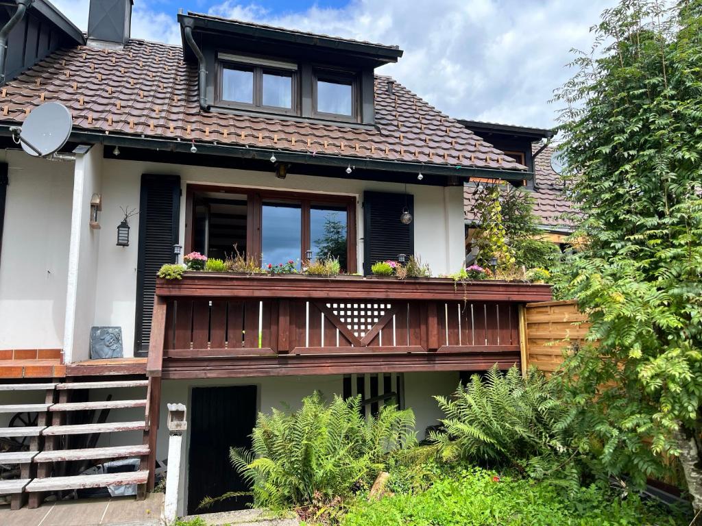 a house with a balcony with flowers on it at Haus am Waldrand in Todtmoos