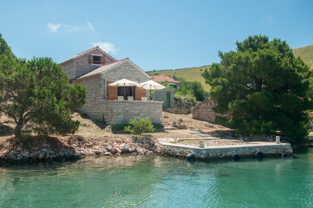 a house sitting on the side of a river at Holiday Home Queen of Kornati in Vrulje