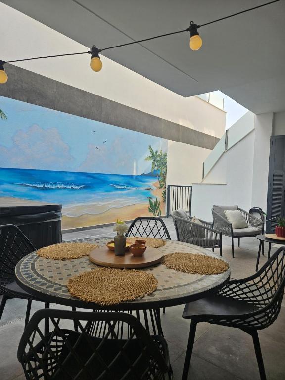 a dining room with a table and chairs and a painting at Casita Feliz in San Pedro del Pinatar