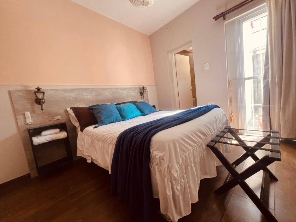 a bedroom with a bed with blue pillows and a window at Colorado in Mendoza