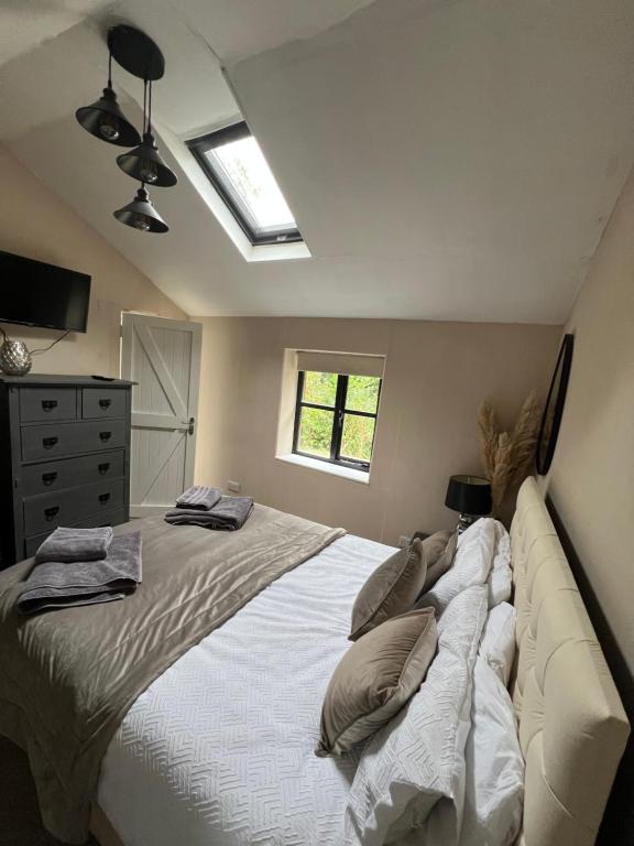 une chambre avec un grand lit avec des oreillers dessus dans l'établissement Storeybook cottage, à Oswestry