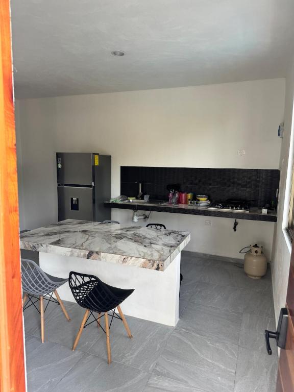 a kitchen with a marble counter top and two chairs at Lindo depto 2 piso cerca de la playa in Chabihau