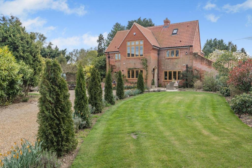 a large brick house with a large yard at The Glebe House in Reepham