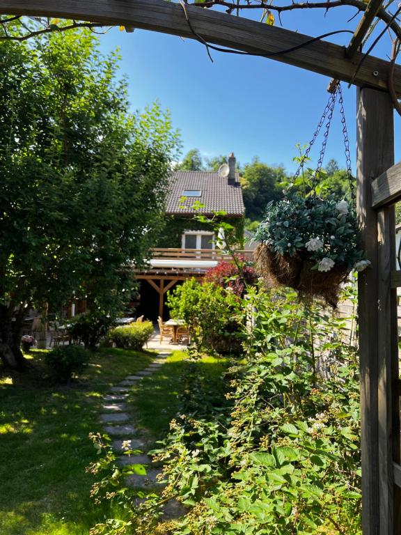 a garden with a house with a hanging basket of flowers at Gîte Les 2 Gros in Pierre-Percée