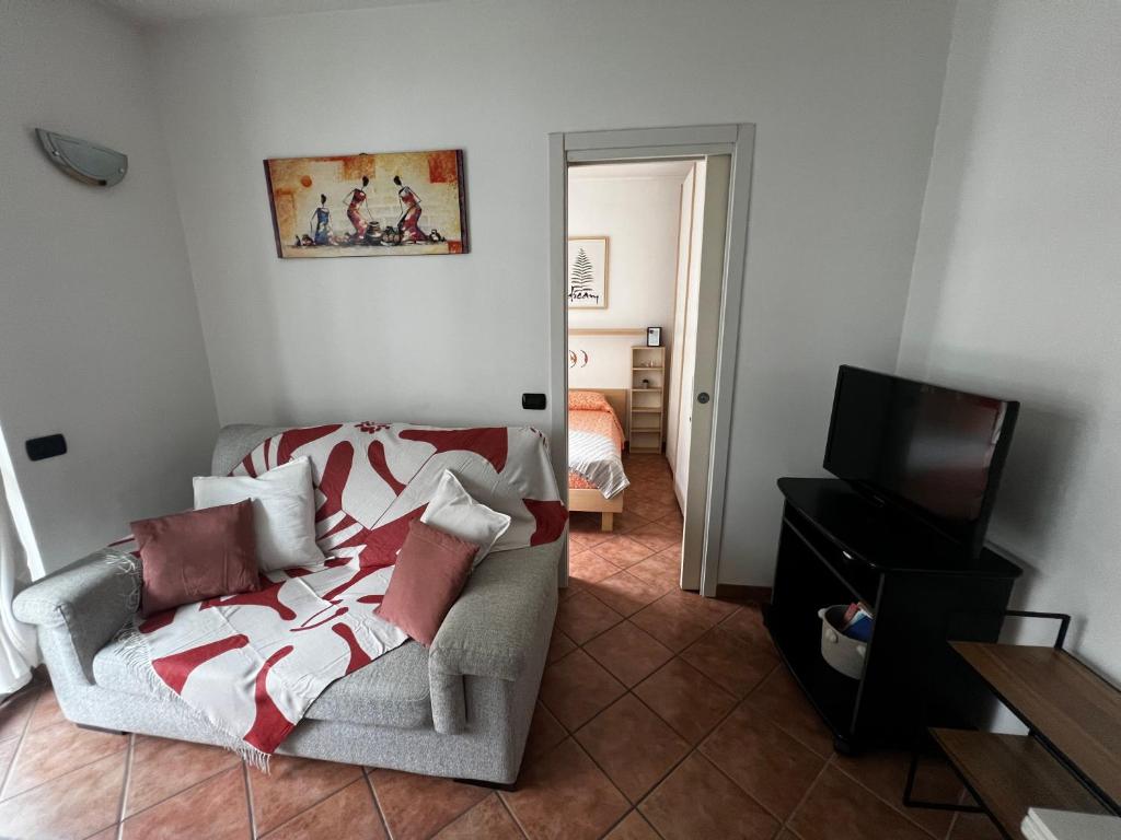 Hotel Gaia holiday, a living room with a couch and a television at Gaia holiday in Milan