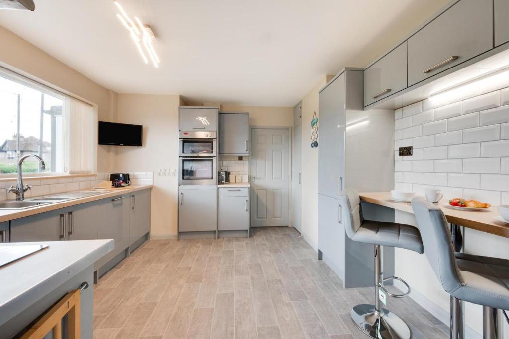 Una cocina con gabinetes blancos y encimera. en LAmourette, en Bacton