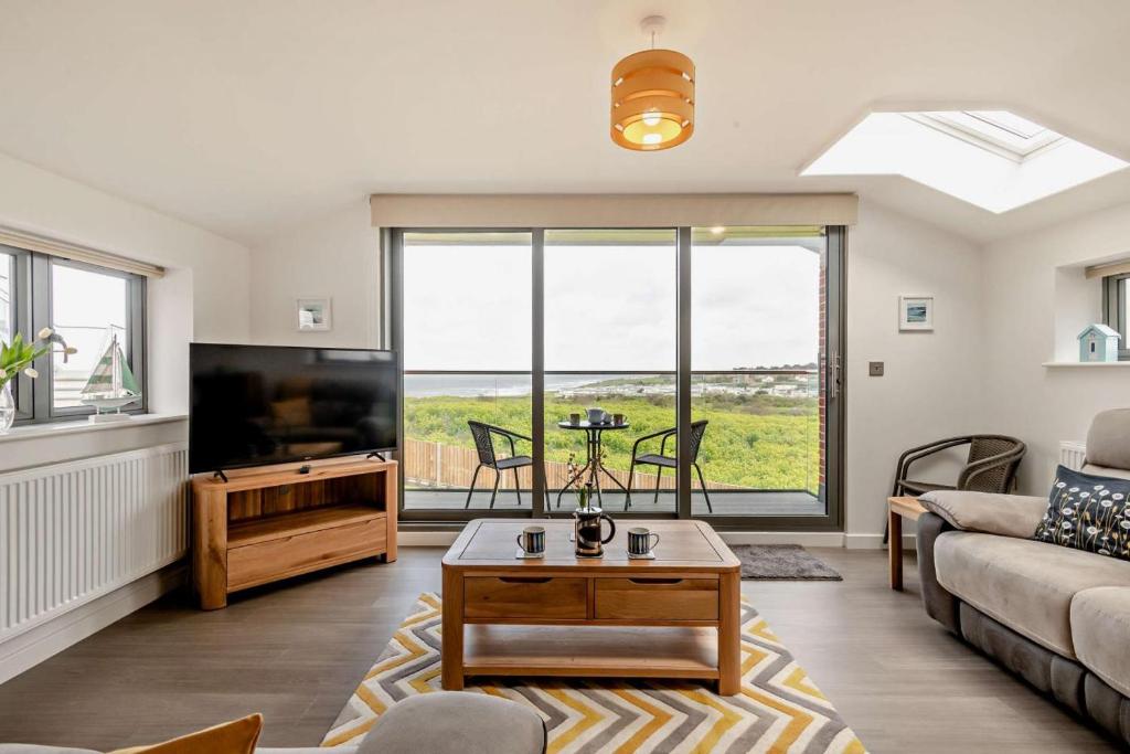 un salon avec un canapé et une télévision dans l'établissement Beeston Sea View, à Sheringham