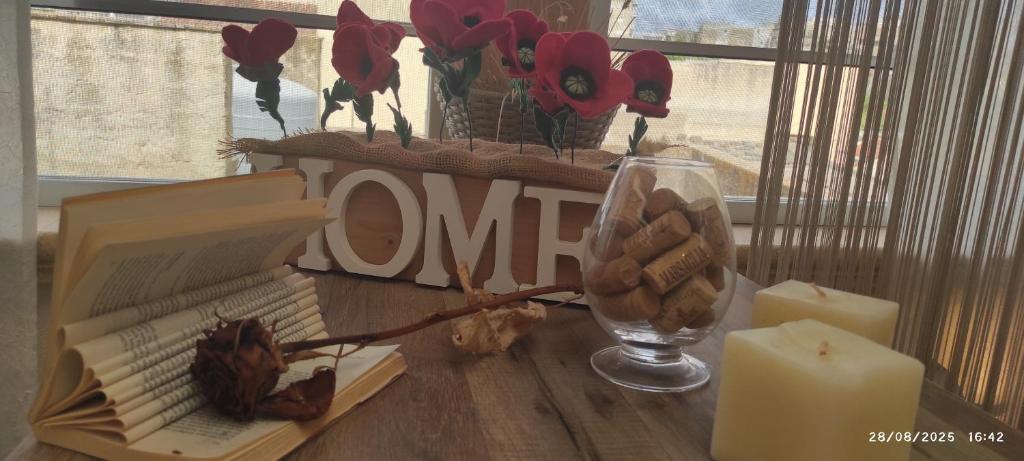 a table with a candle and flowers and a book at HOME DOLCE LUNA in Castelvetrano Selinunte