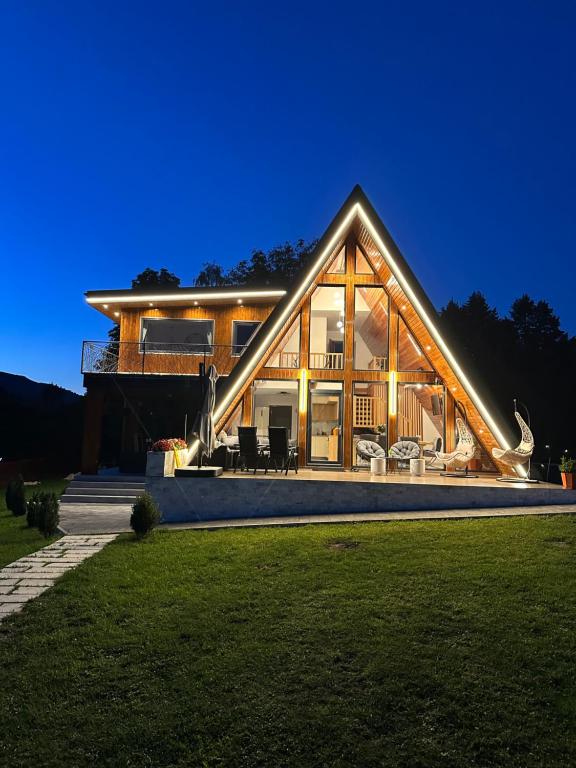 a large house with lights on it at night at Căsuța lui Filip in Teşila