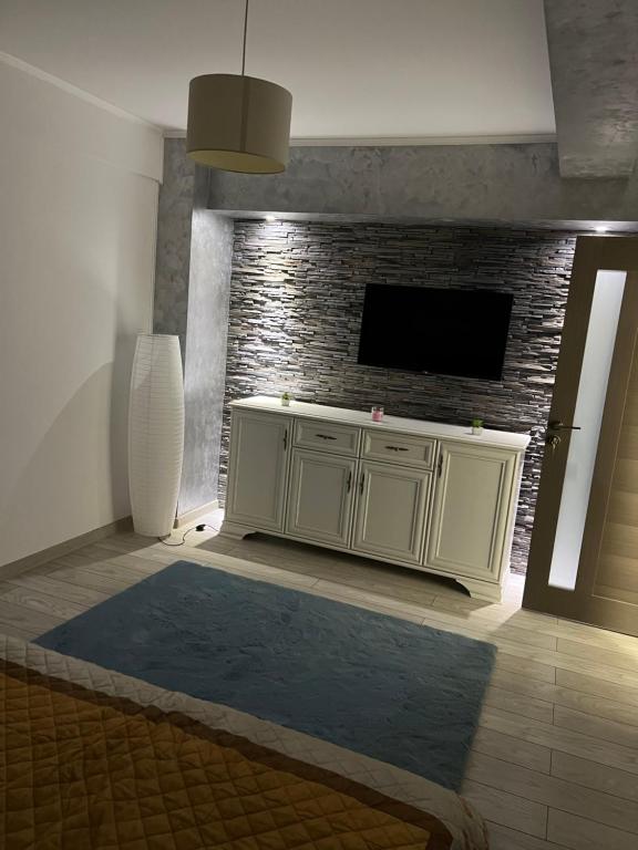 a living room with a tv on a brick wall at Central Luxury Apartament in Tulcea