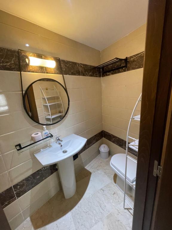 une salle de bain avec un lavabo et un miroir et des toilettes dans l'établissement 2CH & 2 SDB à coté de la gare TGV-climatiseur & fibre optique, à Tanger