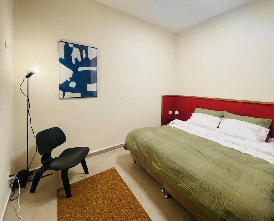 a bedroom with a bed and a chair in it at Charming 1BR in Nachlaot Steps to the Shuk in Jerusalem
