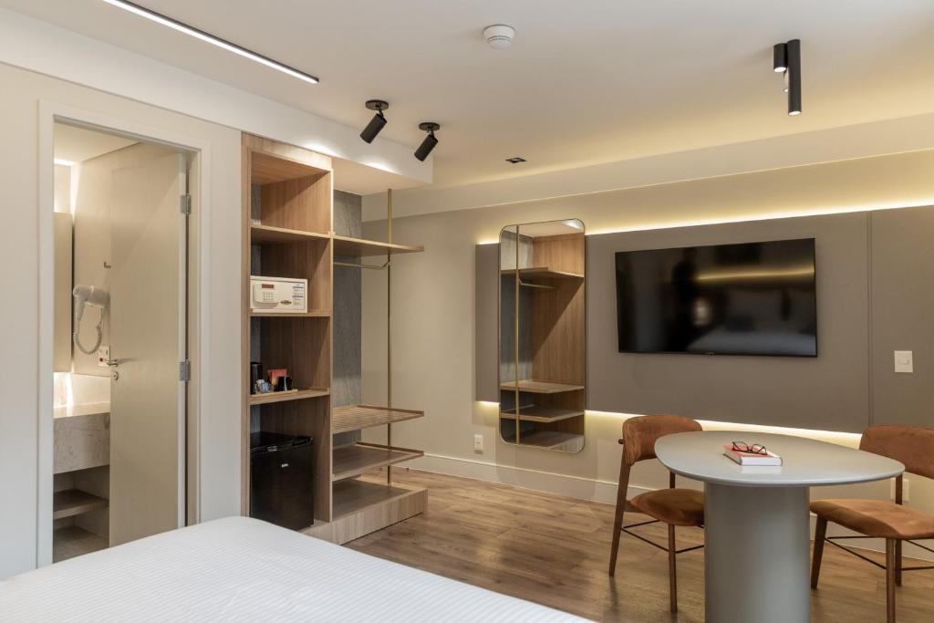 a room with a bed and a table and a tv at Intercity São Paulo Nações Unidas in São Paulo