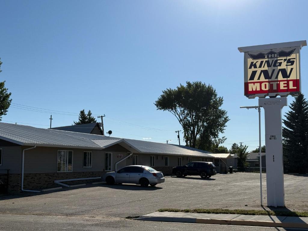 una señal para un motel con un coche aparcado en un estacionamiento en Hotel O The Kings Inn Culberston MT HWY 2, 