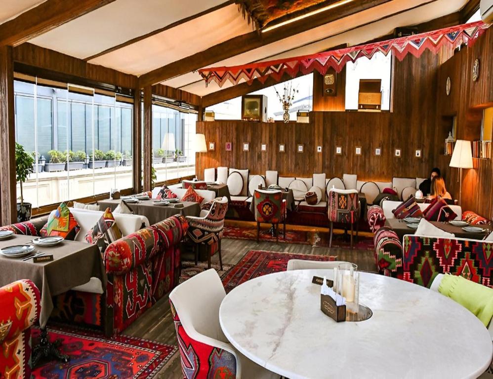 a restaurant with tables and chairs in a room at Baku - Park Azure with sea view two bedrooms and one living room in Baku