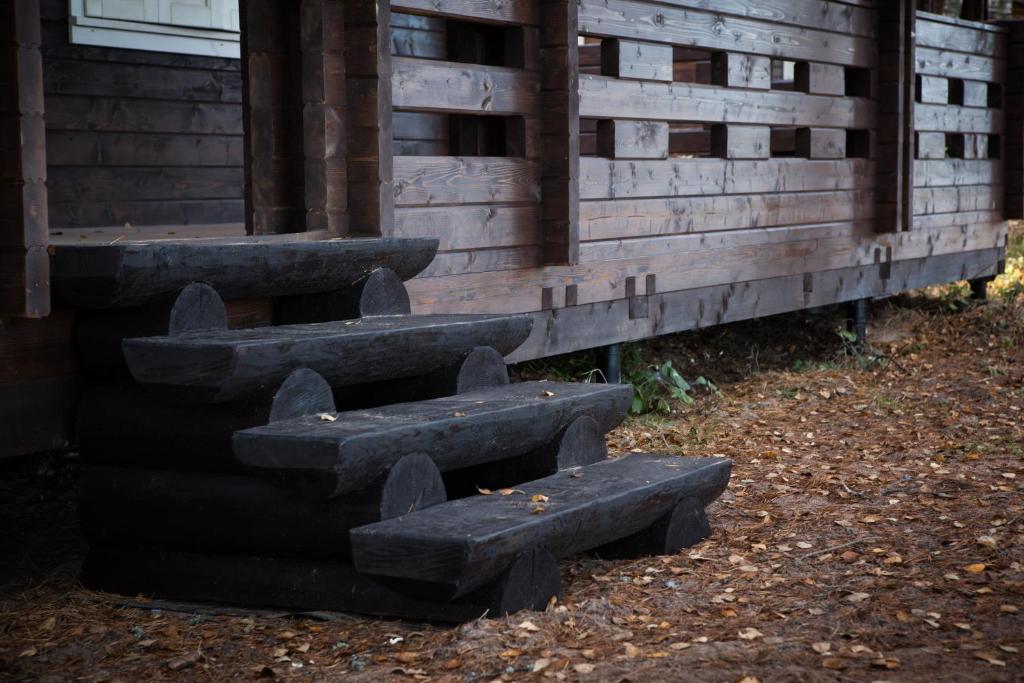 a group of stone benches next to a wooden building at Baza Otdikha Zolotoy Bereg in Zaporozhskoye