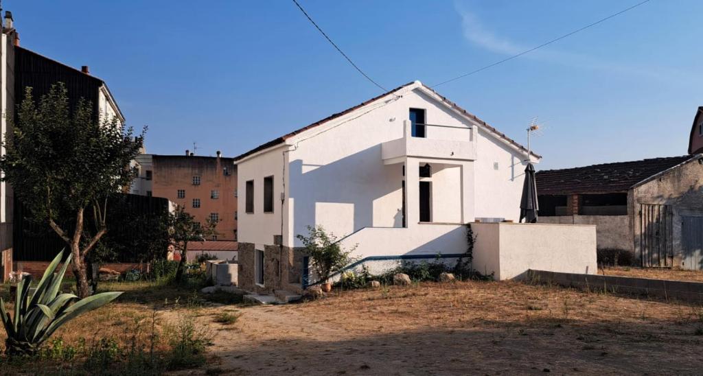 a white house in the middle of a yard at Cesarina Urban Rural House in Chantada