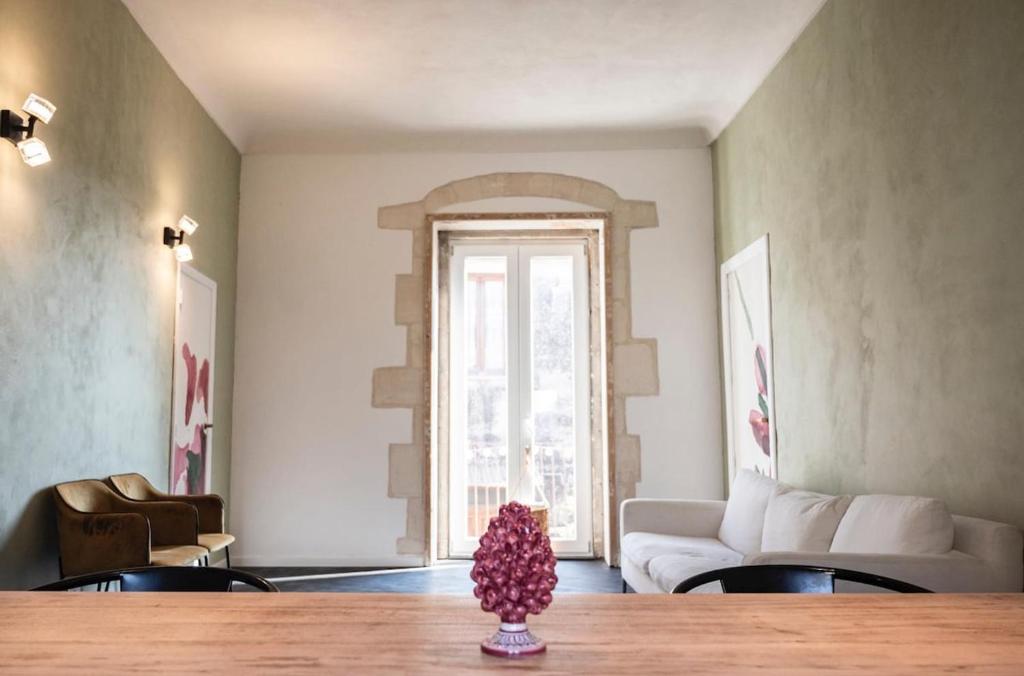 a living room with a table and a couch at Regina Margherita Luxury House in Modica