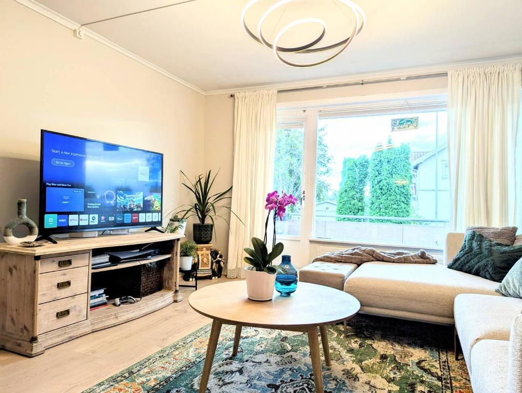 a living room with a couch and a tv at Comfy room - Ski center - near Ås - 11 min to Oslo in Ski