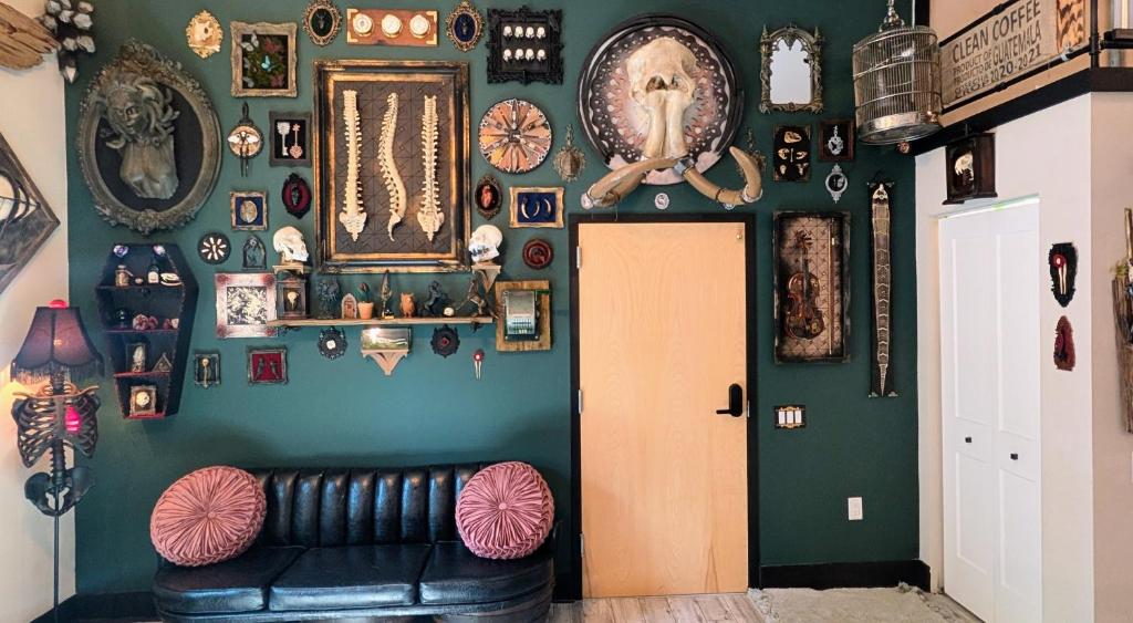 タンパにあるCozy AF Gothic Rose Galleryの黒い革張りのソファと緑の壁のある部屋