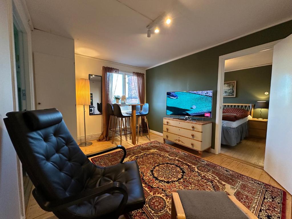 a living room with a black chair and a flat screen tv at Stora Torget B&B in Eksjö