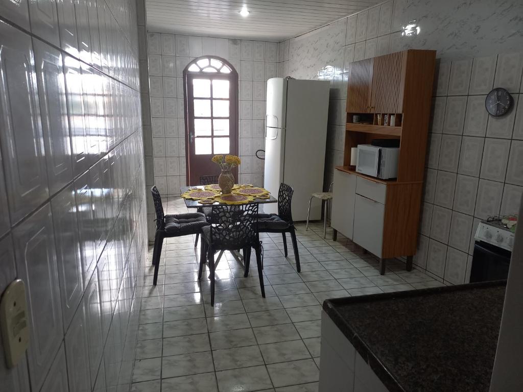 a kitchen with a table and chairs and a refrigerator at Apartamento Ferias e Tarabalho in Vila Velha