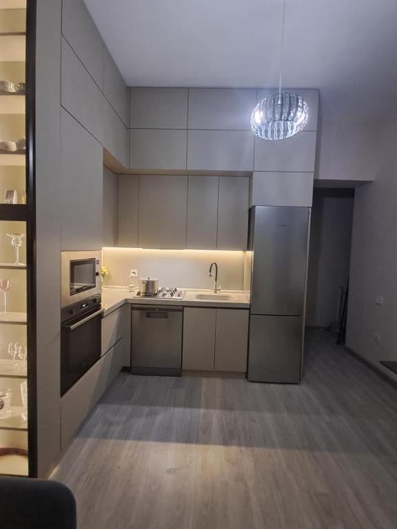 una cucina con mobili bianchi, un lavello e un frigorifero di Appartamento a Baku