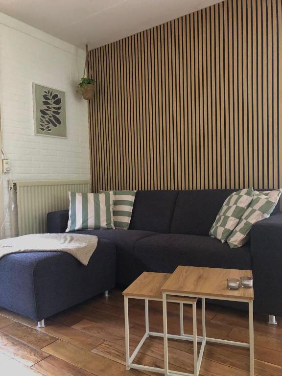a living room with a blue couch and a table at Het Boshuisje in Nunspeet
