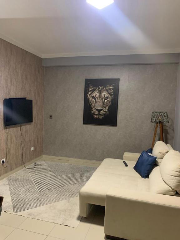 a living room with a bed and a television at Flat Eduardus in Palmas