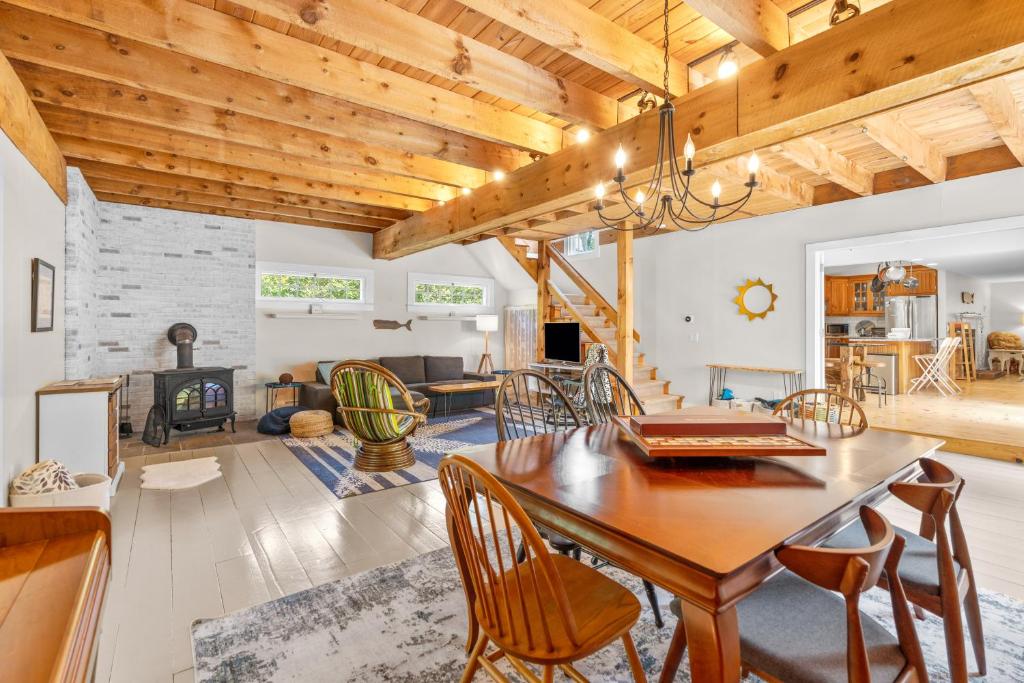 a dining room and living room with a wooden ceiling at Gorgeous Home 1 mile to Beach and near Cape Cod Bikepath in Dennis