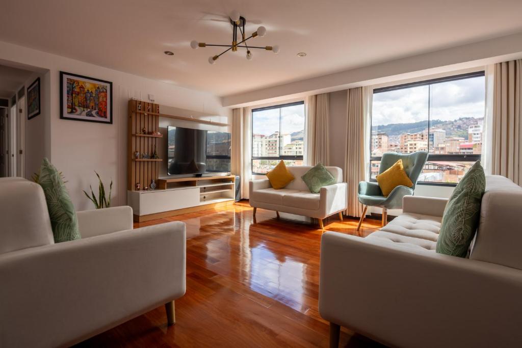 a living room with a couch and chairs and a television at Modern apartment - 10 Min to City Center in Cusco