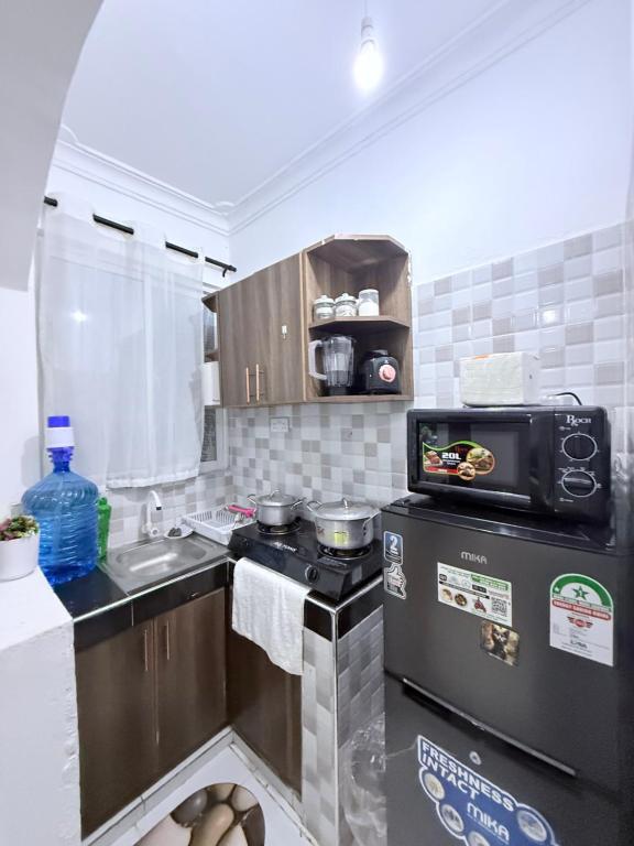 a small kitchen with a stove and a microwave at Bamburi Getaway Studio in Mombasa