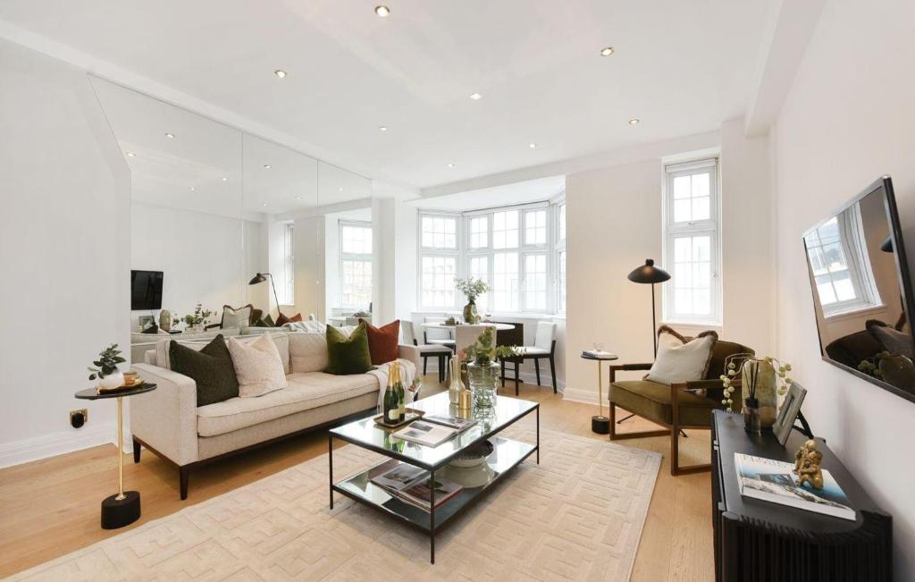 a living room with a couch and a table at Estatesmen Harrods Knightsbridge Apartment in London