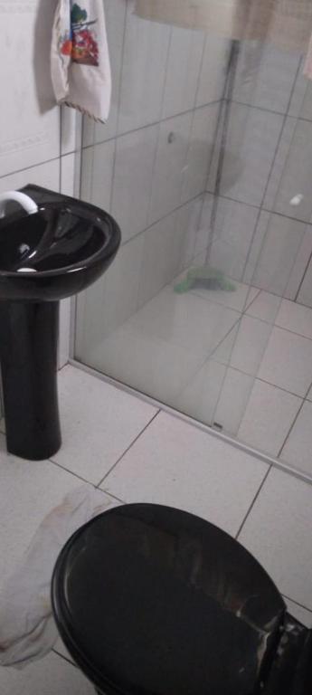 a bathroom with a black toilet and a shower at Casa em Mosqueiro cop 30 in Belém