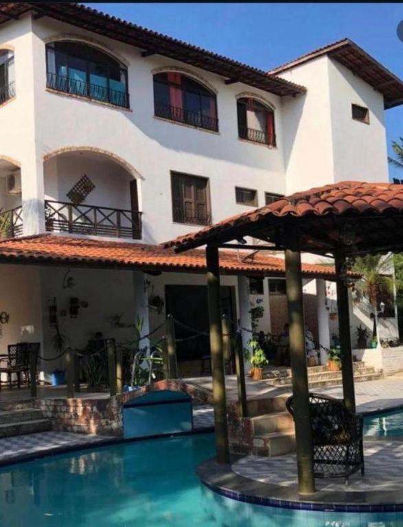 a house with a swimming pool in front of a building at Pérolas Beach Hotel in Paracuru