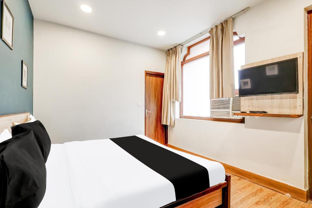 une chambre avec un lit et une télévision au mur dans l'établissement Super Collection O Palam Near Railway Station, à New Delhi