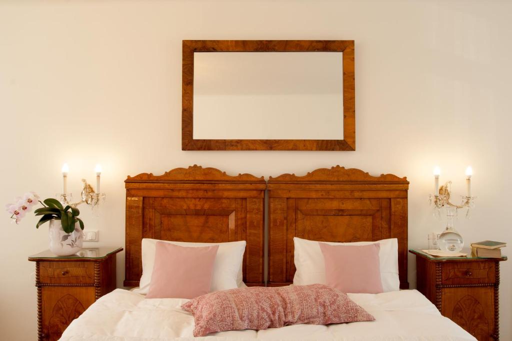 1 dormitorio con cama y espejo en la pared en Austria Classic Hotel Wolfinger - Hauptplatz, en Linz
