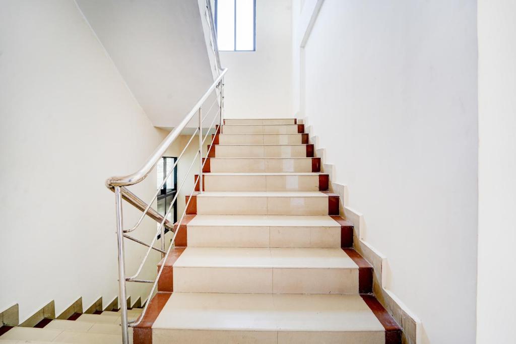 una scala in un edificio con pareti bianche e pavimenti in legno di Super Townhouse Deshabhimani Road Kaloor Kochi a Cochin