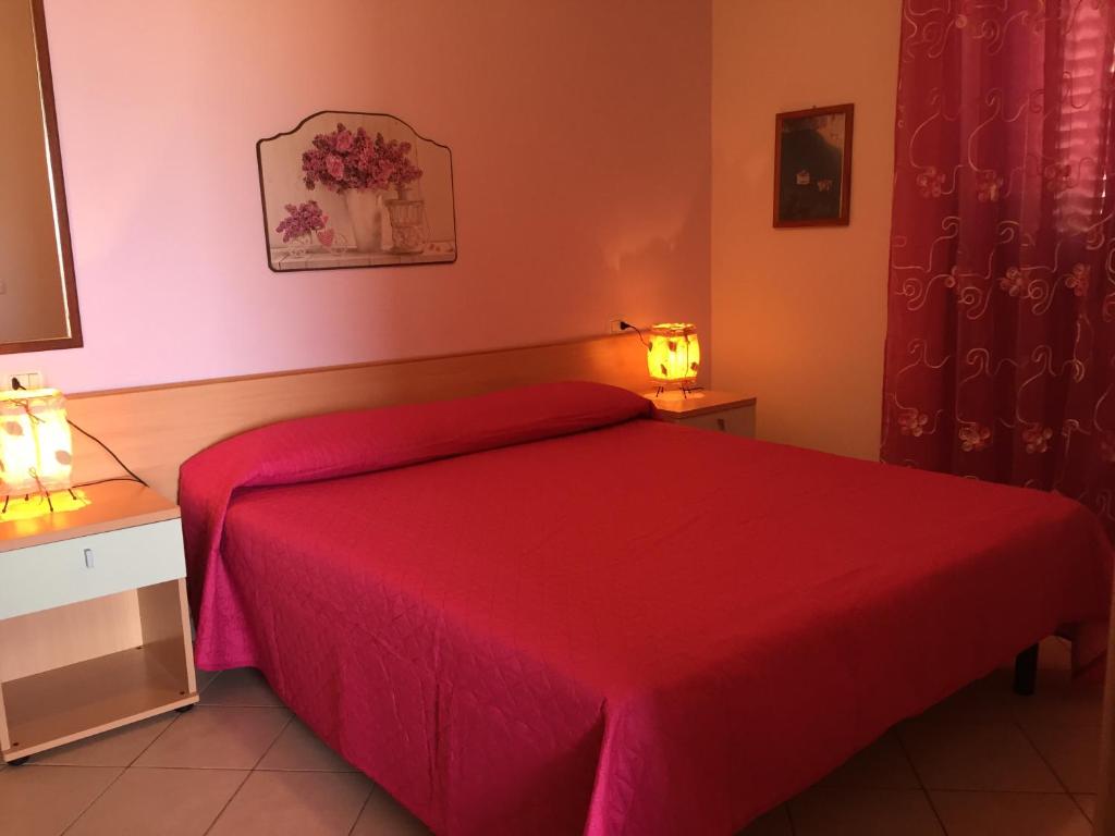 una camera con letto rosso e copriletto rosso di Villa Marilena a Peschici