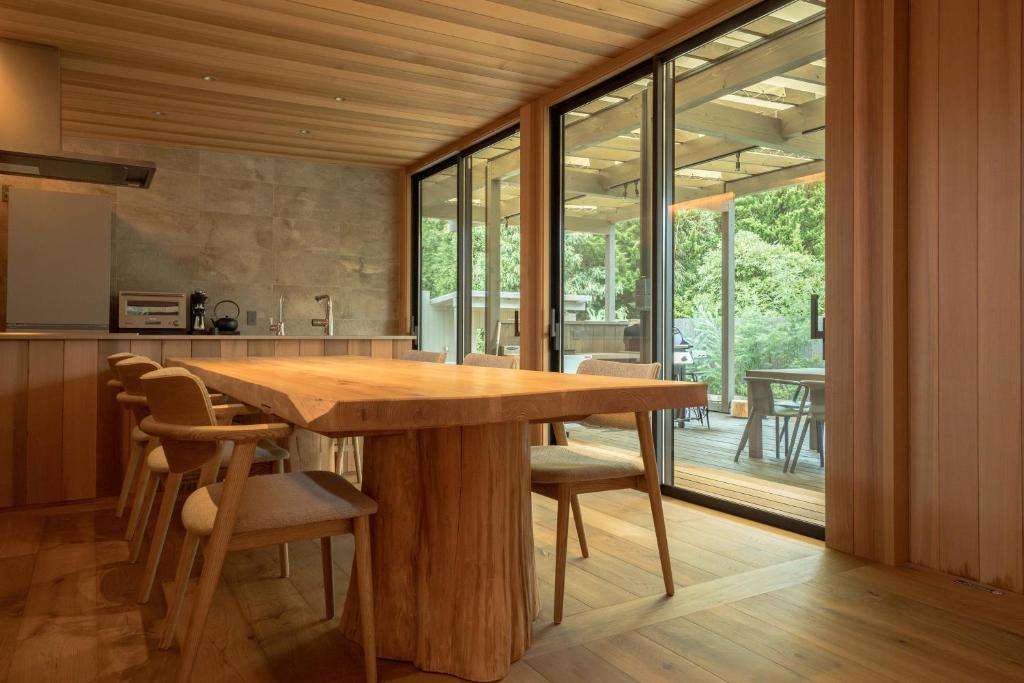 a kitchen with a large wooden table and chairs at Tiny Base The Irita-hama in Shimoda